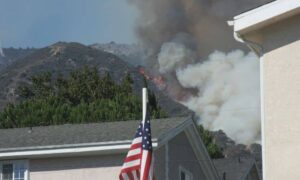 Wildfire burning near hillside homes showing why an ALTA Land Title Survey is essential for accurate property rebuilding after a fire.