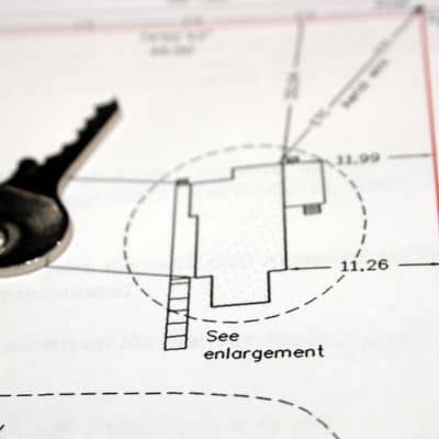 House key resting on a plot plan used during a loan closing survey review
