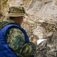 A surveyor documenting measurements in the field while performing a construction survey