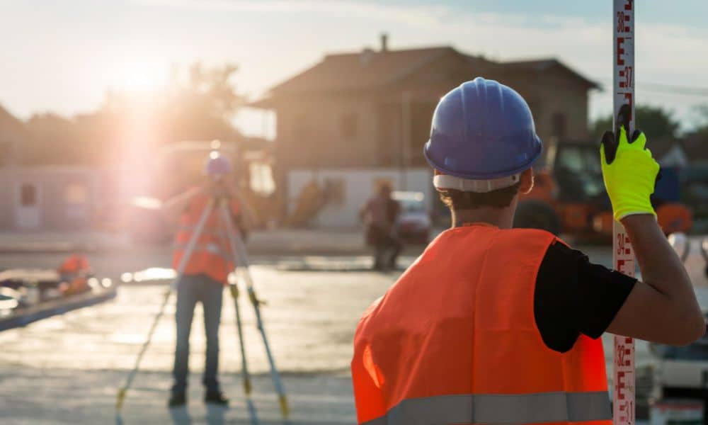 Land surveyor conducting an ALTA survey at a residential property before rebuilding