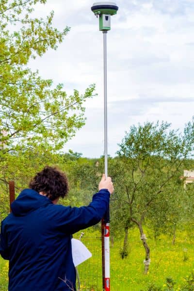 Licensed surveyor using equipment to map property access routes and boundaries for wildfire safety